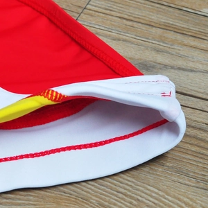 Detailed view of reinforced stitching and tricolor fabric seams on men's swim trunks