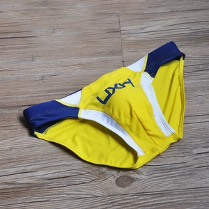 Detail view of yellow men's swim briefs with blue contrast waist and side stripes