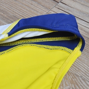 Detailed close-up showing double-needle seam stitching and vibrant contrast colors on swimwear