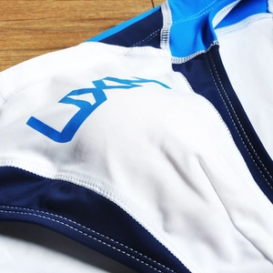 Detailed macro shot of the premium tricolor stitching and LYAN logo on men's swim briefs