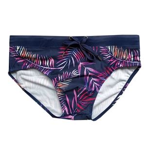 Men's navy swim trunks featuring tropical colorful palm leaf print and adjustable drawstring