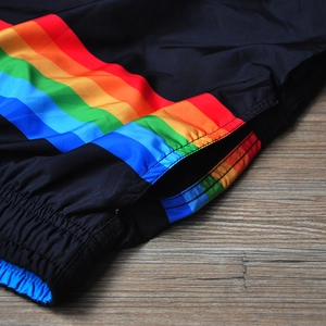 Dettaglio ravvicinato di pantaloncini sportivi neri con strisce arcobaleno laterali