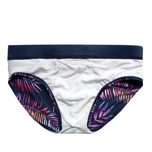 Detail of men's tropical palm leaf print swimwear with navy waistband and mesh panel