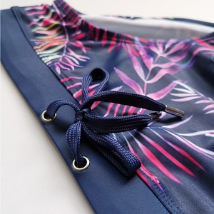 Detail of men's tropical leaf print swim trunks with elastic waist and drawstring
