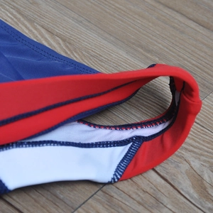 Detail of navy blue swim trunks featuring red contrast piping and durable flatlock stitching