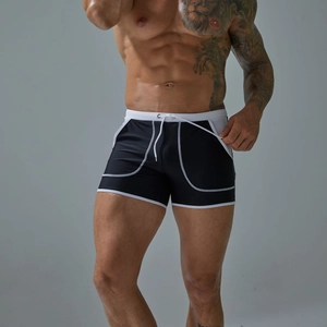 Detailed view of men's swim trunks with white drawstrings and side pockets in black nylon