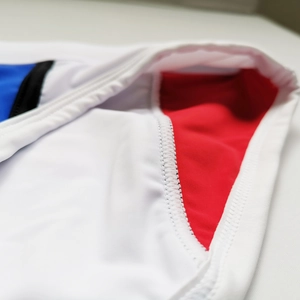 Macro shot showing reinforced stitching on red white and blue swimming trunks