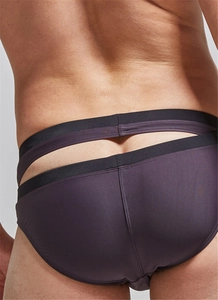 Detail view of purple men's swim briefs featuring a unique black hollow-out cutout design