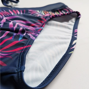 Detail of tropical palm leaf print bikini bottoms with white lining and double stitching