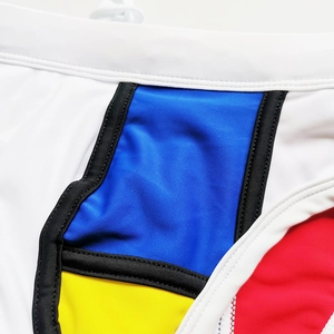 Macro view of geometric color-block patchwork and stitching on men's swim briefs