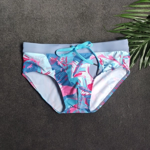 Dettaglio di un costume da bagno da uomo con stampa tropicale e cordoncino blu regolabile