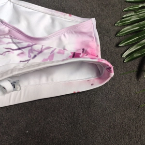 Macro detail of men's pink tie-dye swim briefs with elastic waistband and drawstring