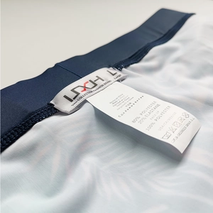 Detailed view of UXH swim briefs waist label showing L size and polyester fabric blend