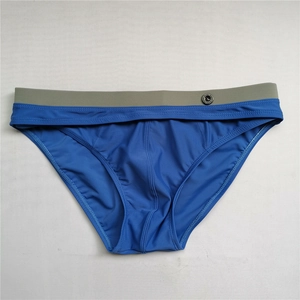 Detail of navy blue swim briefs with grey contrast waistband and circular branding logo