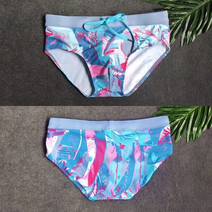 Vista dettagliata fronte e retro dello slip da nuoto uomo con stampa tropicale e coulisse