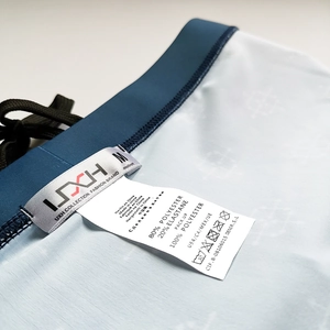 Detail view of elastic waistband with drawstring and M size wash care label on swim trunks