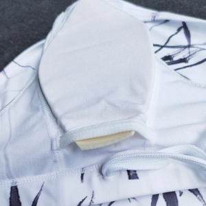 Detail of men's swim trunks featuring a removable padded cup and ink leaf print lining