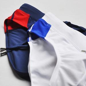 Detail of color-block swimming briefs with adjustable drawstrings and metallic aglets