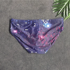 Detail shot of men's swim briefs with colorful pixel mosaic print and elastic waistband