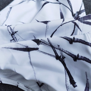 Detailed macro view of ink-wash bamboo print and high-elastic fabric on swim trunks
