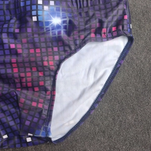 Detail of pixel square print swim trunks showing side stitching and soft white lining