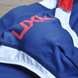 Detail of navy swim trunks featuring flatlock seams and athletic color-block design