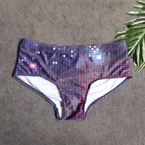 Detail of purple square-cut swim trunks with geometric pixel pattern on textured grey mat
