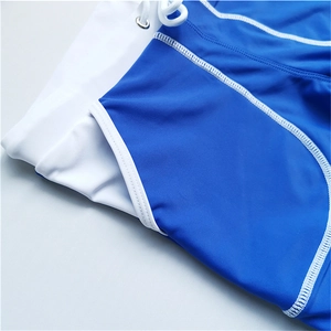 Detail of blue and white swimwear fabric featuring precise stitching and adjustable drawstrings