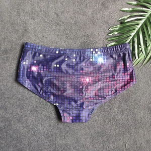 Detail view of mens swim trunks featuring retro pixel patterns and elastic waistband