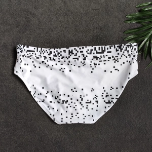 Detail view of men's briefs with white digital pixel print on a dark textured background