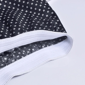 Macro detail of men's cotton boxers showing white clover print and elastic waistband