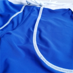 Detail of blue men's swim shorts featuring white contrast stitching and quick-dry fabric