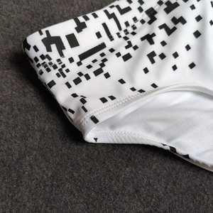 Detail of swimsuit with black pixel print and durable flatlock double-stitching