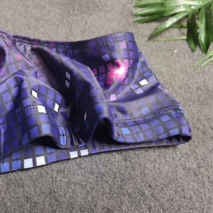 Detailed macro view of pixelated neon grid print on stretchy mens swimming trunks fabric