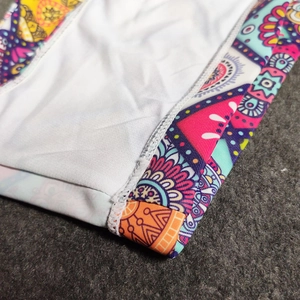Close-up of ethnic mandala print and durable double-stitch seam on men's swim trunks