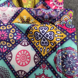 Detailed close-up of bohemian mandala print and stitching on men swim trunks