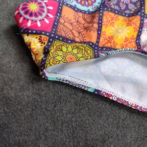 Detailed close-up showing bohemian mandala print and professional white overlock stitching