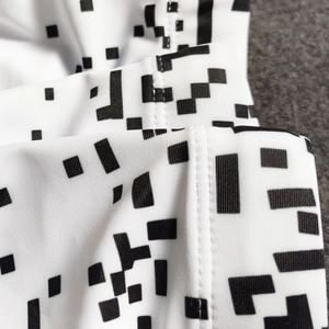 Detail view showing black and white geometric pixel pattern and flat seam stitching