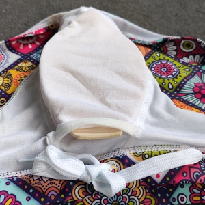 Detail view of ethnic print swimwear featuring removable white sponge pads and tie strings