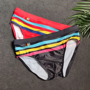 Close-up of quick-dry men's swim briefs featuring colorful rainbow striped side panels