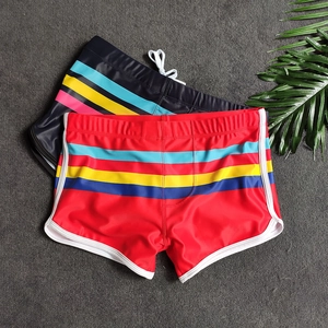 Flat lay of men's quick-dry swim trunks with contrast stripes and white drawstring