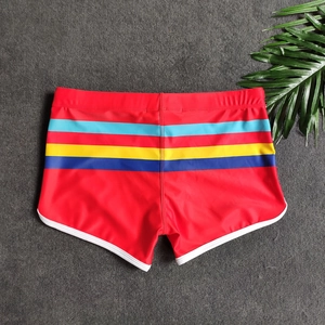 Macro shot of red swim trunks featuring color stripe accents and white binding trim