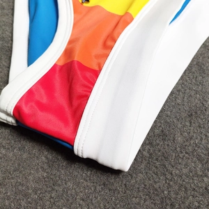 Close-up of color-block swim briefs showing vibrant panels and elastic white trim