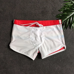 Flat lay of men's white split-leg swim trunks with red elastic waistband and white drawstrings