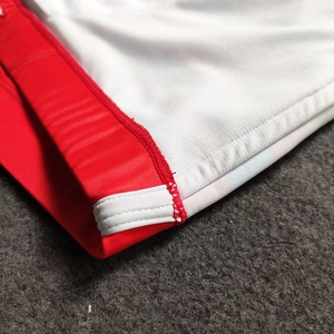 Detail of red and white striped men sports shorts showing reinforced stitching seams