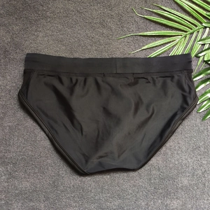 Flat lay of men's black quick-dry swimming trunks with mesh panels and wide waistband