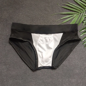 Close-up of black men's triangle swim briefs featuring breathable white mesh splice detail