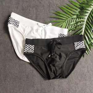 Flat lay of men's quick-dry triangle swim trunks with side geometric pattern and drawstrings