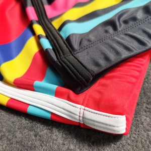Close-up of vibrant striped swim trunks featuring reinforced stitching and elastic fabric