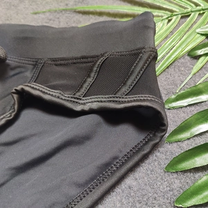 Detail view of men's black swim briefs featuring mesh panels and elastic waistband